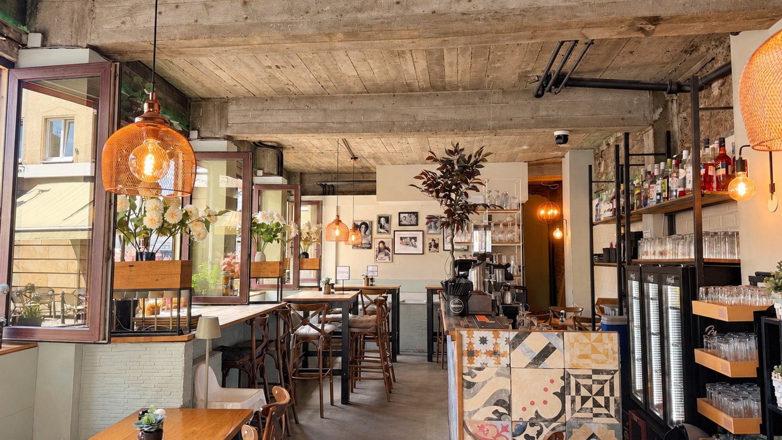 Gastraum von Pizza Pasta Lucca mit offener Fensterfront, Hochtischen mit Hockern und fliesenverkleideter Theke